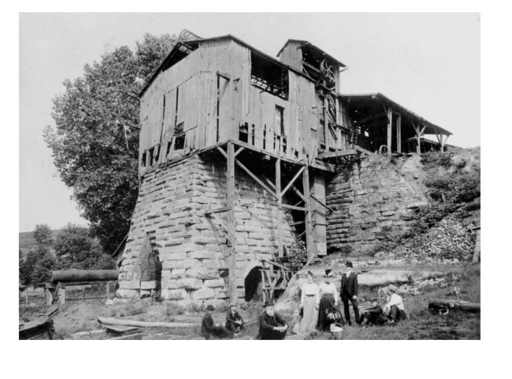 Reproduction of a photograph depicting a group of picnickers at the ruins of Pine Grove Furnace in Lawrence County, Ohio, ca. 1905. Pine Grove Furnace was built in 1828. Wilbur Stout, former chemist at the Columbus Iron and Steel Company and Ohio's state geologist, researched and collected photographs of blast furnaces in Ohio. He received this photograph from Arthur S. Kiefer of Columbus, Ohio. Date of Original ca. 1920-1935 Collection Wilbur Stout/Blast Furnaces Collection from Ohio Memory website